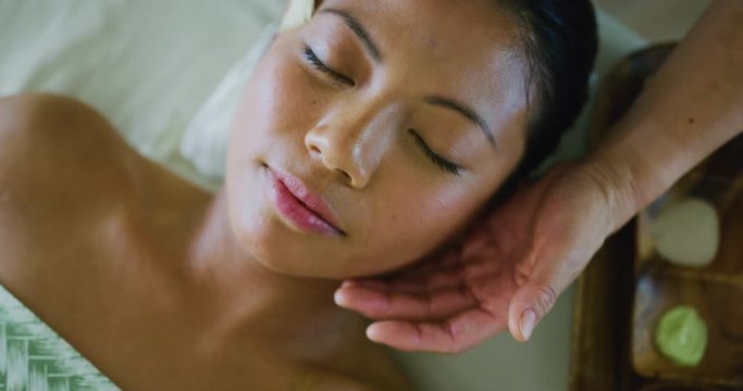 Woman relaxing receiving facial treatment at the spa