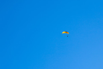 a paraglider flying in blue sky on mountains and valleys landscape in Georgia