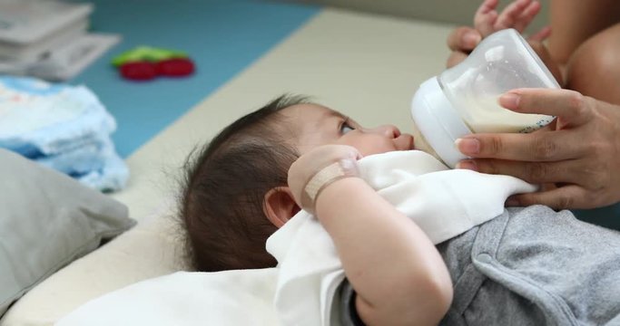 baby sucking milk from bottle