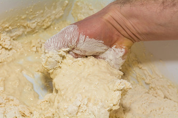 the chef's hands knead the dough to make pizza in the kitchen. Food, italian cuisine and cooking concept. Preparation of the Italian Pizza