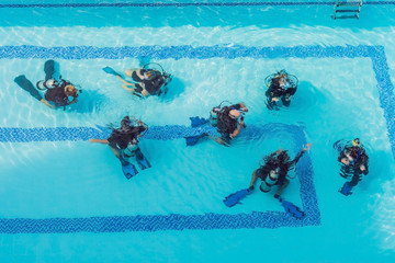 Diving instructor and students. Instructor teaches students to dive