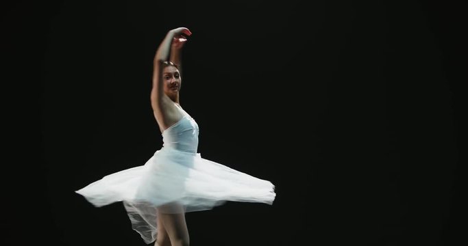 4K video footage beautiful elements of classic ballet ballerina dancing on black background, slow motion