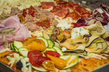 Rectangular shape and thick hand made focaccia pizza. Close-up. Food, italian cuisine and cooking concept. Preparation of the Italian Pizza