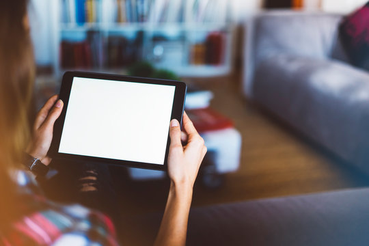 Hipster girl using tablet technology in home atmosphere, girl person holding computer with blank screen on background bokeh, female hands texting on holiday, mockup templates gadget