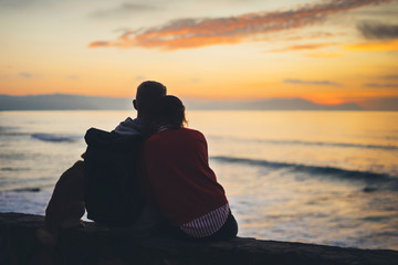 Couple hugging on background beach ocean sunrise, silhouette two romantic people cuddling and looking on rear view evening seascape, hipster enjoy sunset together, travel holidays vacation