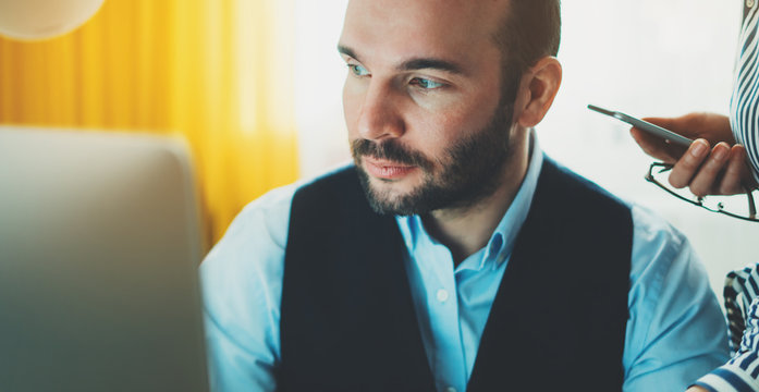 Bearded young businessman working on modern office at night. Consultant man thinking looking in monitor computer. Manager typing on keyboard in coworking workplace, startup project concept in studio