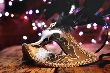 beautiful carnival mask on wooden table and on blur lights background