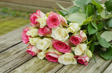 pink and white roses on the wooden table