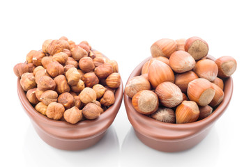 hazelnuts in clay bowl on white background