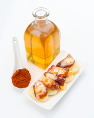 Marinated octopus sliced on potatoes isolated on white
