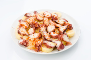 Marinated octopus sliced on potatoes isolated on white