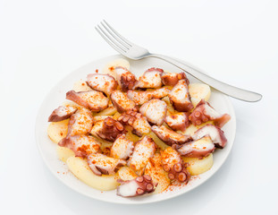 Marinated octopus sliced on potatoes isolated on white