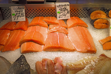 Fresh salmon fillets for sale on ice in supermarket store in fridge display. Red fish.