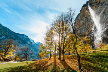Beautiful autumn time at village of Lauterbrunnen in Swiss alps, gateway to famous Jungfrau. Set in a valley featuring rocky cliffs and the roaring, 300m-­high Staubbach Falls