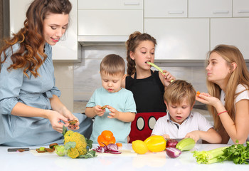 mother with children preparing vegetables in the kitchen