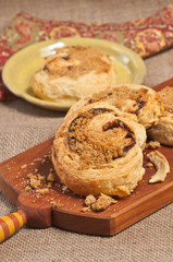  Close up of freshly baked, homemade, warm, cinnamon rolls on an artisan, wood serving board 