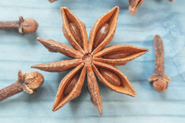 Star anise, cinnamon sticks and cloves on a nintage background.