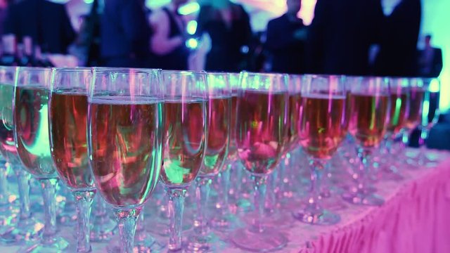 glasses with white sparkling wine in row at restaurant event