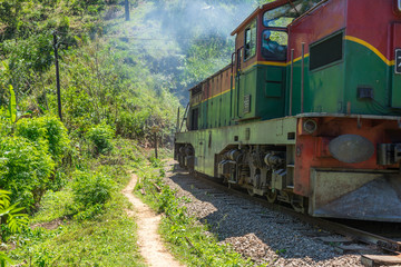 Obraz premium Shortly behind the nine arches bridge between Demodara and Ella, the track leads through a tunnel. The locomotive is on the way to Ella, in the highlands of Sri Lanka