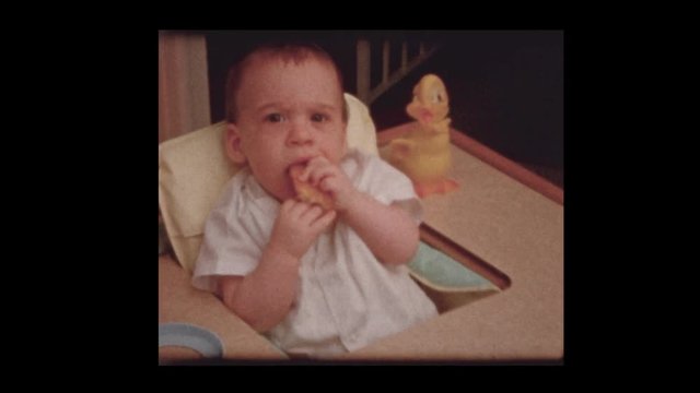 1959  Infant baby boy eating in antique vintage high chair