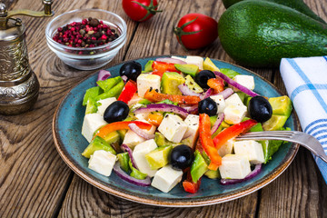 Vegetable salad with feta on wooden background