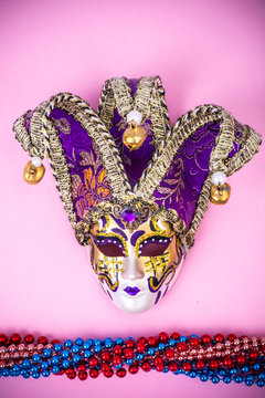 Festival Mardi Gras mask and multicolored beads on bright background