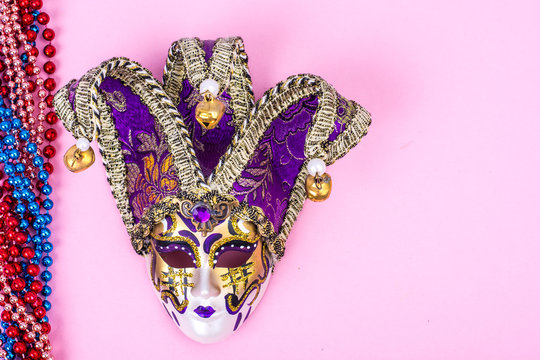 Festival Mardi Gras mask and multicolored beads on bright background