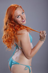 Obraz premium Bright redhead in turquoise bikini