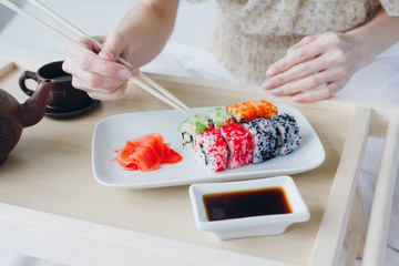 Young brunette woman eating sushi