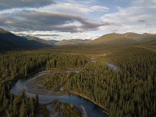 River in the Canadian Wilderness. The sun sets and casts a gold hue over the remote land. The river...