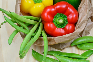 colorful paprika, peas and zucchini on wooden table