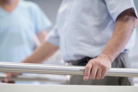 Man using parallel walking bars in hospital