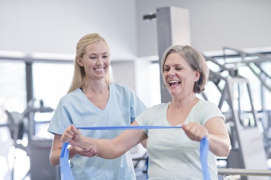 Nurse showing woman how to use resistance band