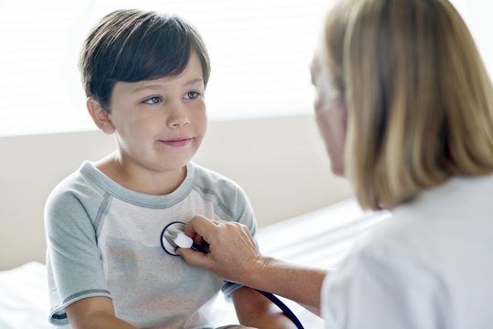Boy looking towards nurse with stethoscope