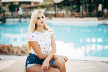 Beauty blonde woman enjoying vacation holidays at hotel resort with swimming pool near the beach