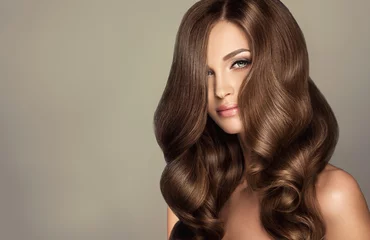 Stickers pour porte Salon de coiffure Belle fille modèle avec de longs cheveux ondulés et brillants. Femme brune avec une coiffure frisée