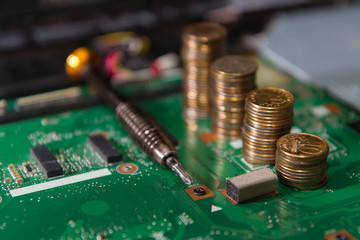 circuit board green with tools and coins close-up