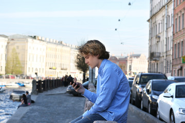 Teenage boy typing text message.Using smart phone