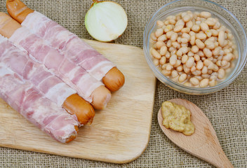 bacon wrapped sausages with white beans 