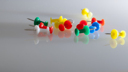 Thumbtacks whit reflections on grey background