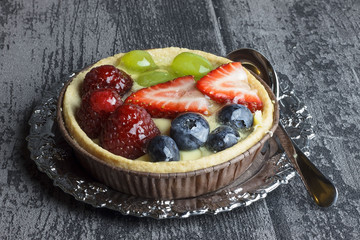 Fresh fruit tart. Delicious cake with blueberry, strawberries and grapes.