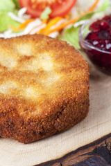 Panierter Camembert mit Salat auf Holz