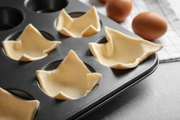 Baking mold with dough on table, closeup