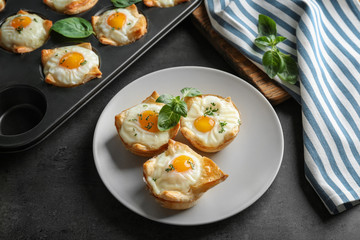 Tasty baked eggs in dough on plate
