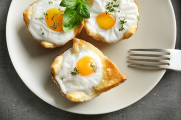 Tasty baked eggs in dough on plate