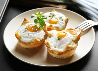 Tasty baked eggs in dough on plate