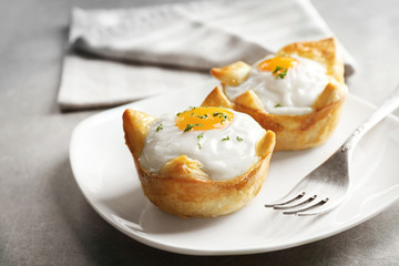 Tasty baked eggs in dough on plate