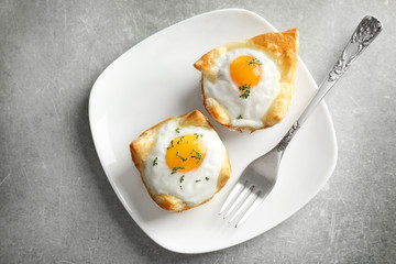 Tasty baked eggs in dough on plate