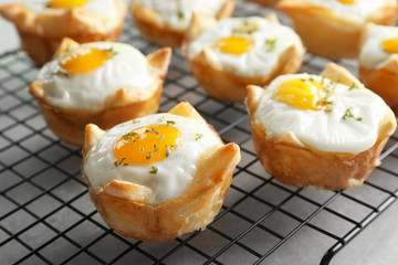 Tasty baked eggs in dough on cooling rack