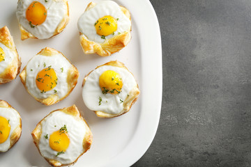 Tasty baked eggs in dough on plate